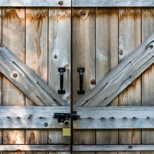 Deux portes en bois avec une serrure de chaque côté, typiques d'un cabanon.