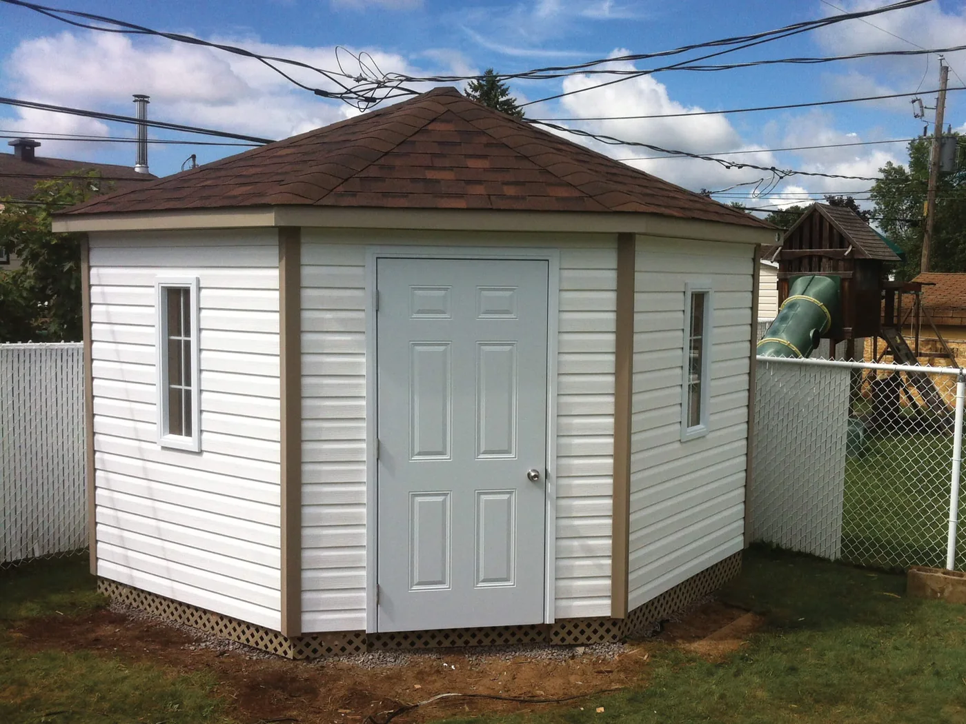 Cabanon blanc à façade en angle avec doubles portes pleines.